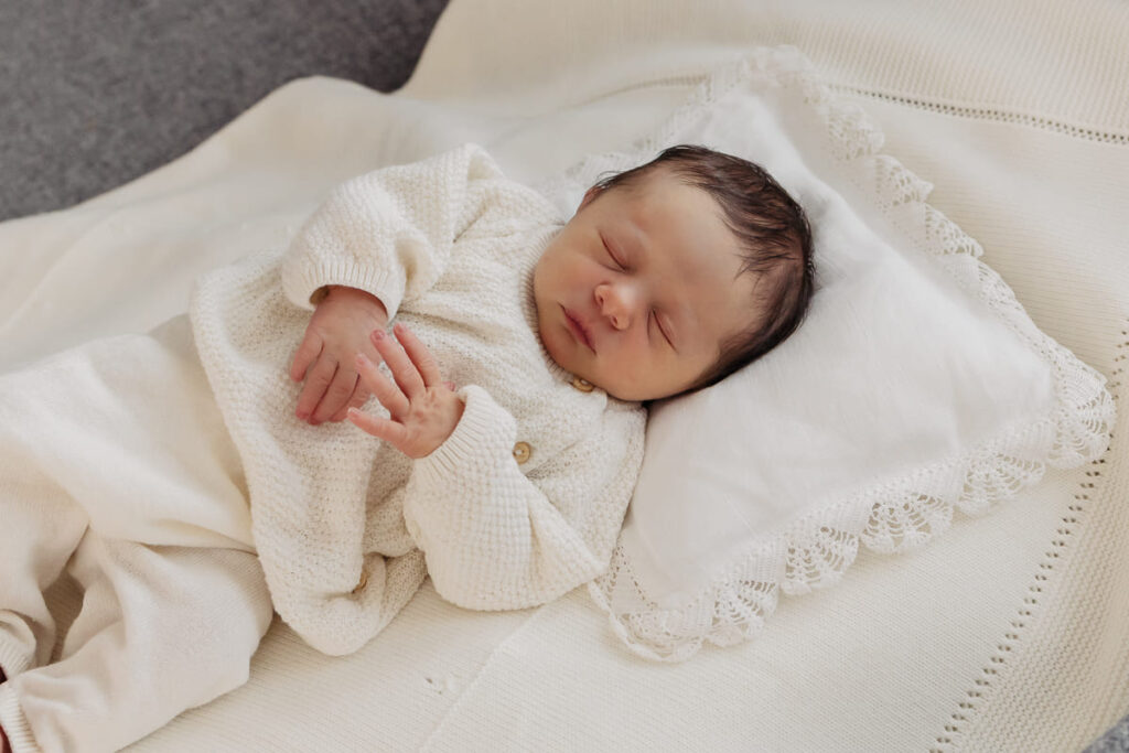 Neugeborenes Baby in neutralem Outfit beim Newborn Shooting