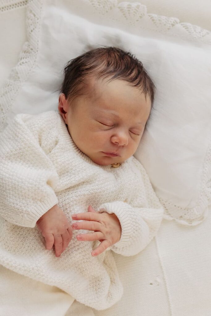 Neugeborenes Baby in neutralem Outfit beim Newborn Shooting