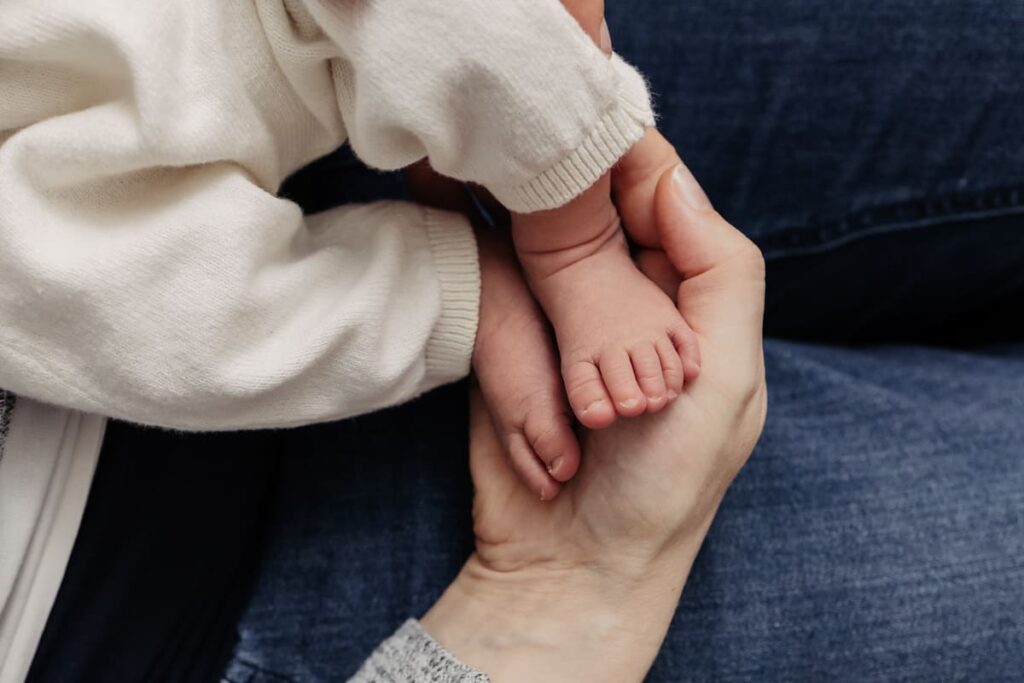 Neugeborenes Baby in neutralem Outfit beim Newborn Shooting