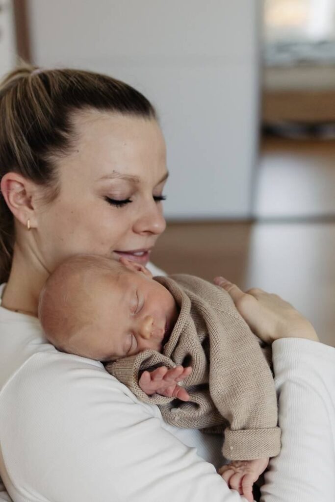 Baby Fotoshooting Zürich, Mama hält ihr schlafendes Baby an der Schulter