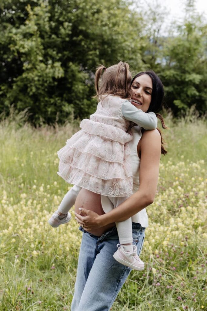 Babybauch Shooting Zürich, Mama und Tochter auf der Wiese