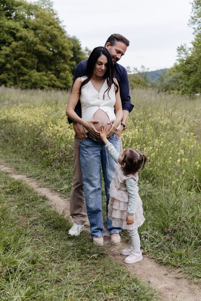 Familie berührt gemeinsam liebevoll den Babybauch