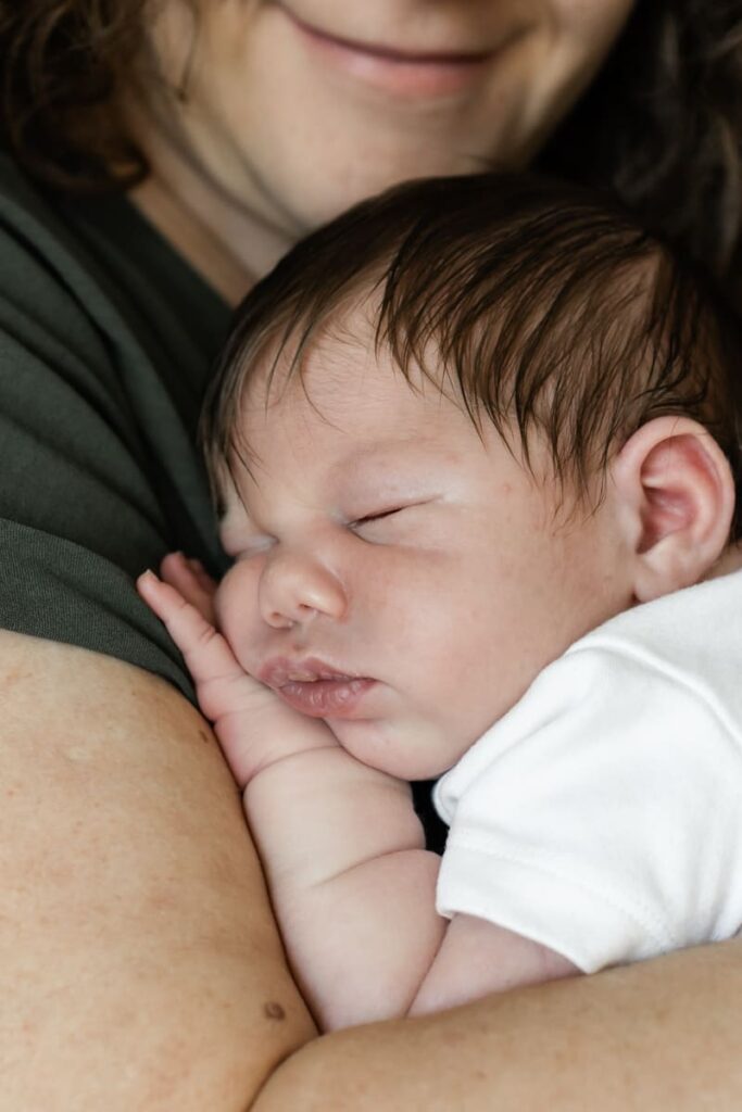 Newborn Fotoshooting Zürich, schlafendes Baby auf Mamas Arm