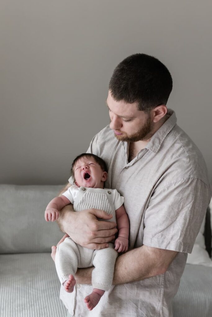 Newborn Fotoshooting Zürich, Papa mit gähnendem Baby
