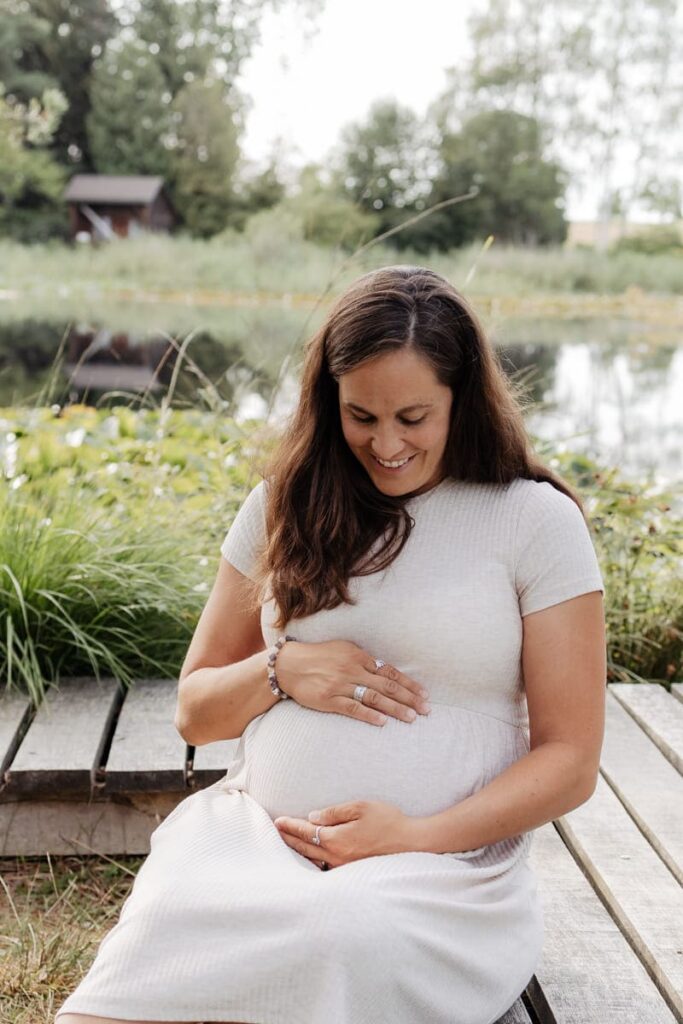 Babybauchfotos Zürich, Mama sitzt entspannt am See