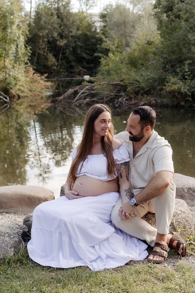Babybauch-Fotos in der Natur: Paar am Wasser